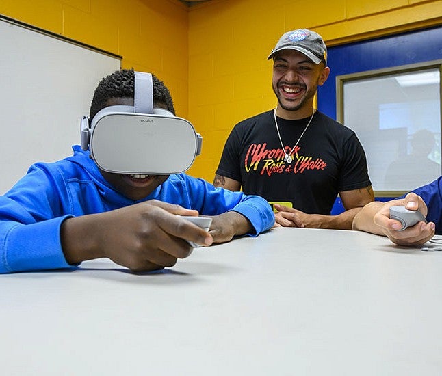 Danny Pimentel works with a student wearing a VR headset
