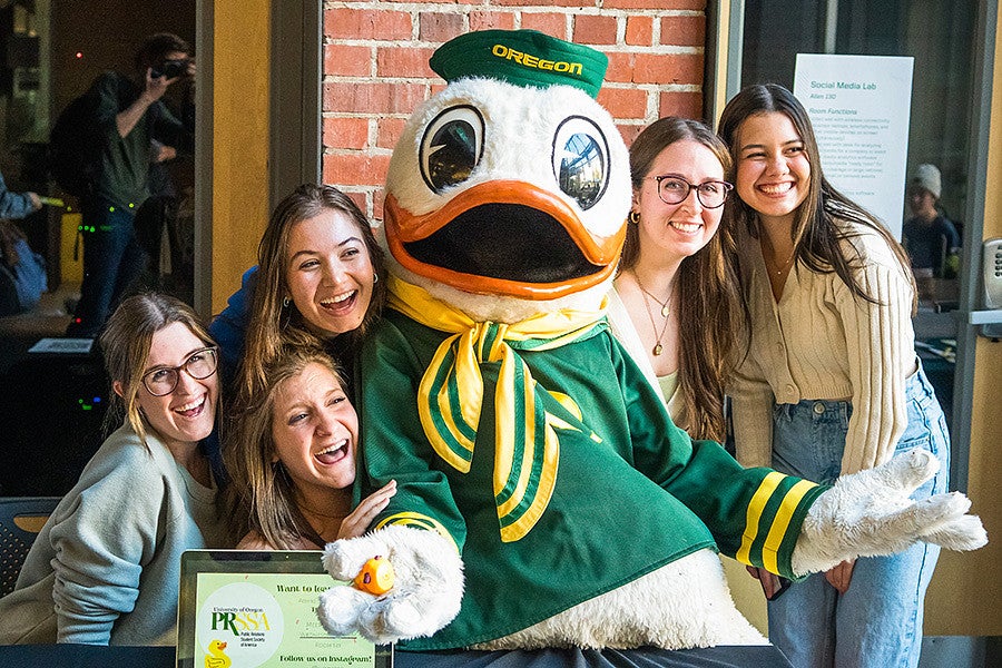 students pose with the UO Duck mascot