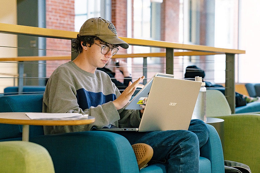 a student uses a laptop and tablet in Allen Hall