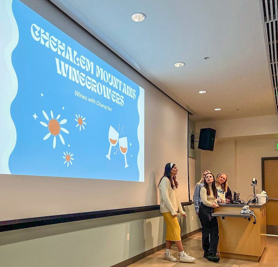 students present in front of a display screen