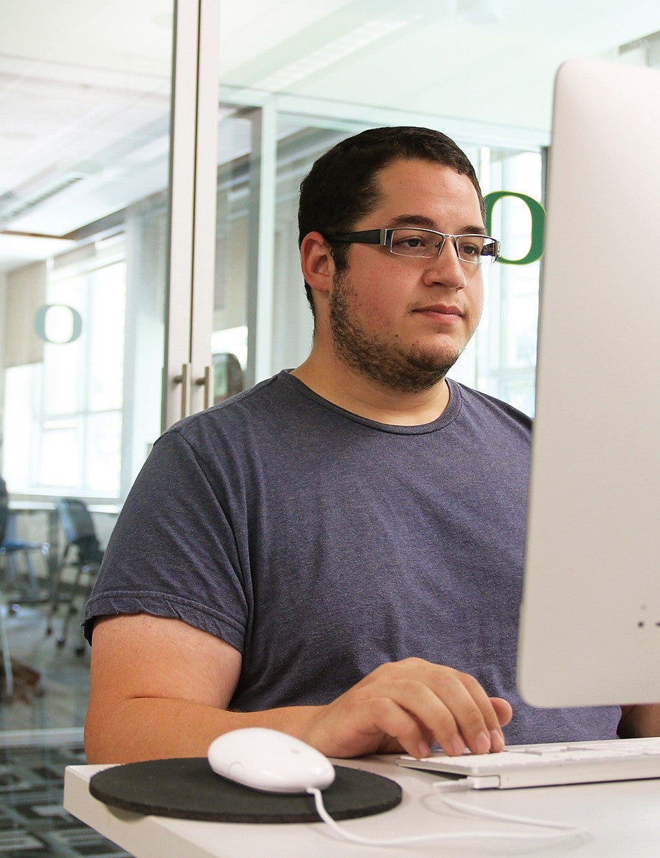 A male student working on a desktop computer