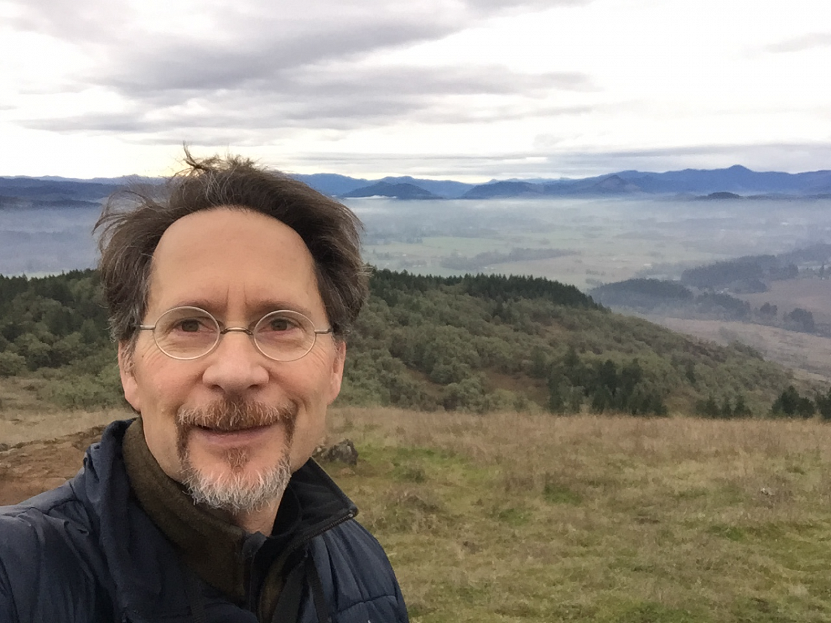 Chris Frisella takes a selfie in front of a cascading mountain view. Chris Frisella takes a selfie in front of a cascading mountain view.