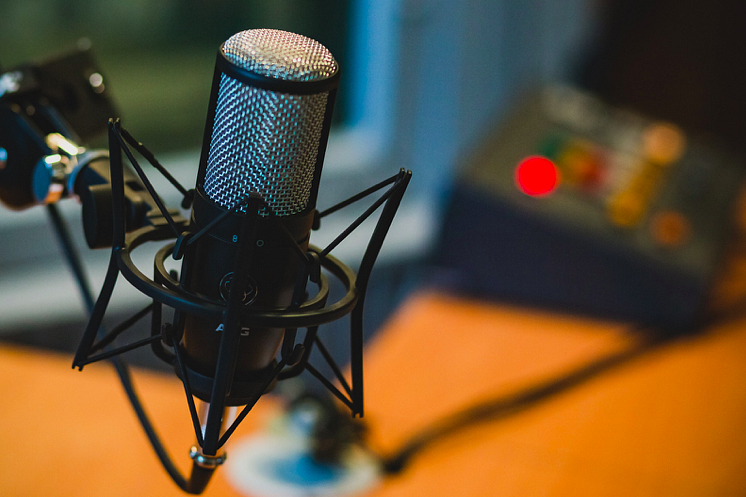Podcast microphone in front of audio mixer.