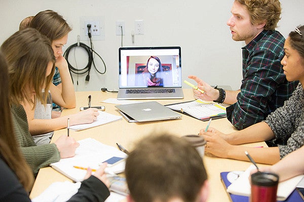 Group of students sitting around a table Group of students sitting around a table
