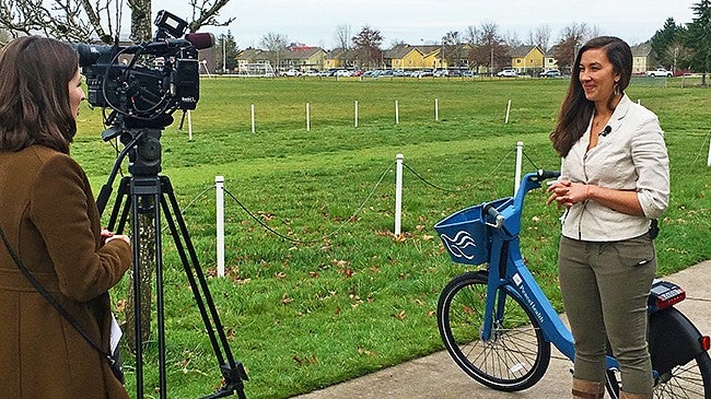 A female student being interviewed on camera in front of a PeaceHealth Rides bike