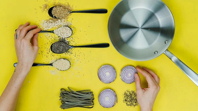 overhead view of cooking utensils and ingredients on a bright yellow background