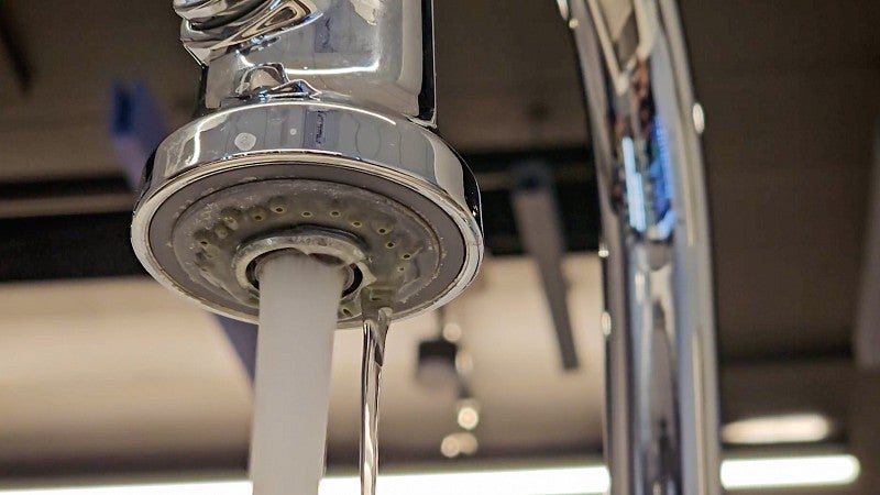 close-up of a standard faucet with running water