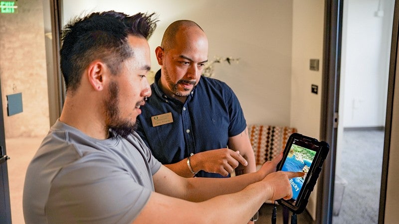 two people explore a virtual reality environment on a small tablet