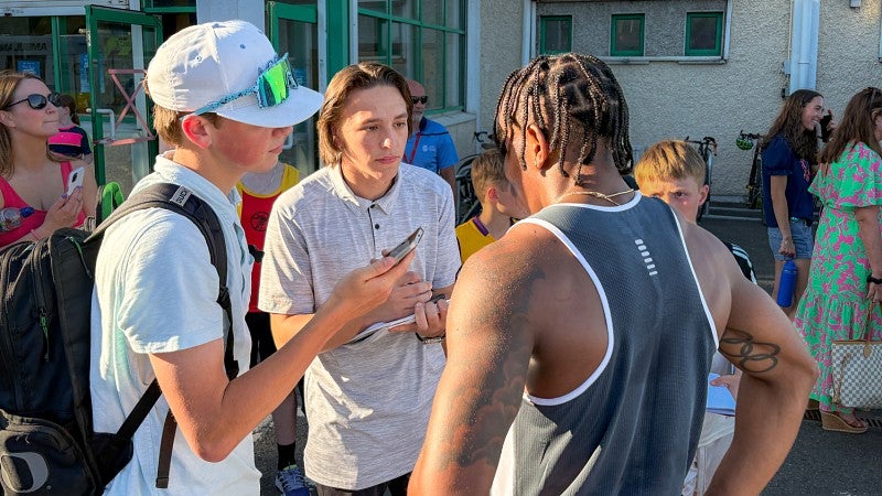 two University of Oregon School of Journalism and Communication students interview an athlete