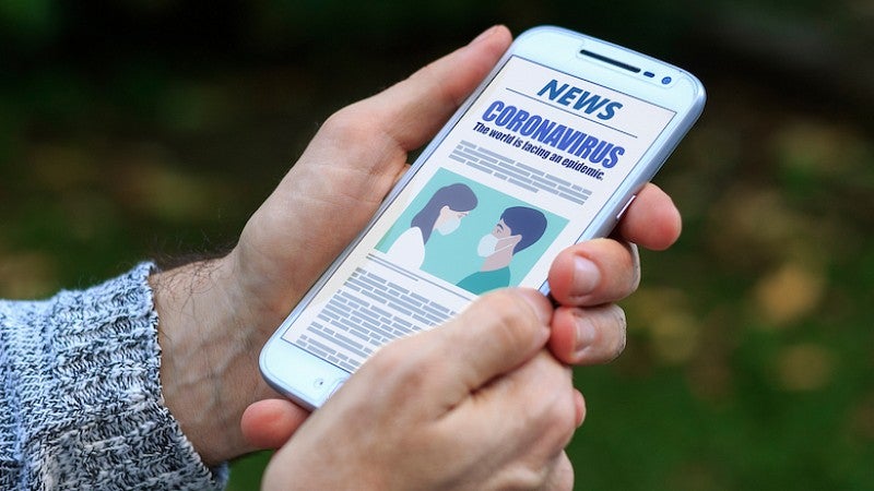 Coronavirus news update on cell phone screen Coronavirus news update on cell phone screen