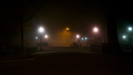 photo of the university of oregon campus at night with pastel colored street lights glowing in the mist