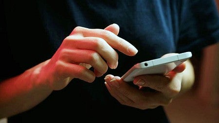 stock photo of a person's hands using a cell phone
