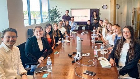 several SOJC PR students pose while sitting around a conference table on a professional development trip