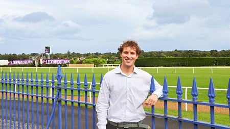 Jack Lazarus poses against a blue fence