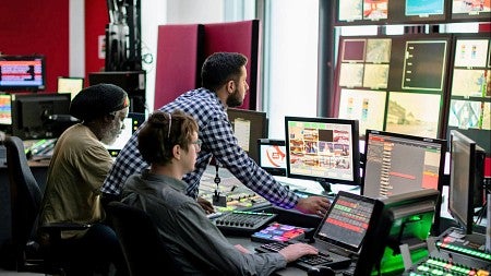 three people operate television broadcast monitors