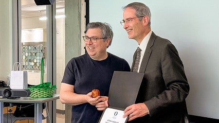 Damian Radcliffe accepts a UO distinguished teaching award from University of Oregon Provost Chris Long