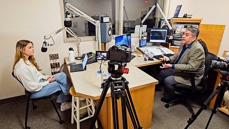 Julia Boboc and Brian Bull sit across from each other while recording a podcast in the KLCC studio