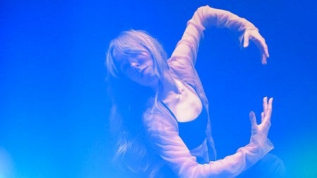 stylistic portrait of Georgia Tucker in a dancer's position with vibrant blue lighting