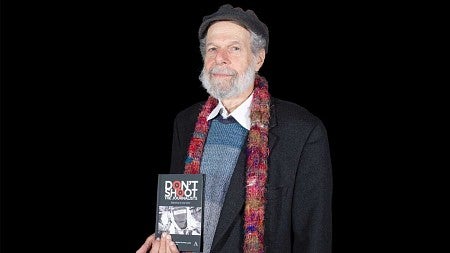 Peter Laufer poses with book title 