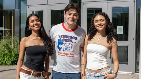 three University of Oregon students pose outside of the Erb Memorial Union