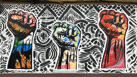 Painted raised fists symbolizing solidarity and support.