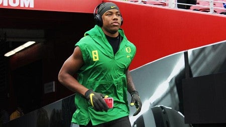 Jevon Holland runs towards the field in UO gear.