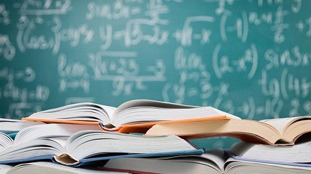 Books in front of a chalkboard.