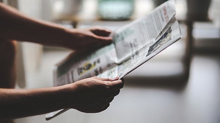 Person reading a newspaper.