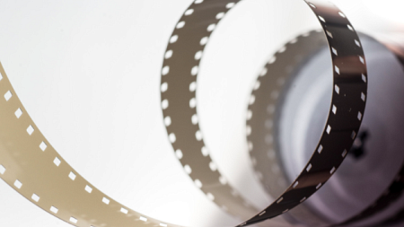 A black roll of film unravels towards the camera (By Skitterphoto from Pexels).