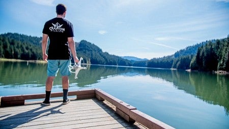 Sean Haney holding a drone by lake