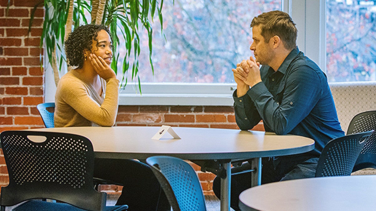 Two students sitting together at round table