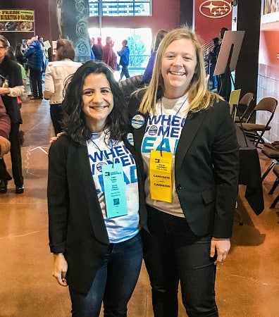 Serena woods and a colleague wear conference lanyards