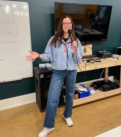 Eva Camacho presents in front of a white board