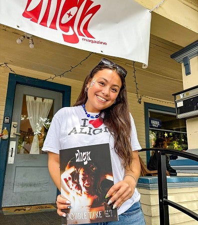 Sydney Seymour posing with a copy of Align Magazine