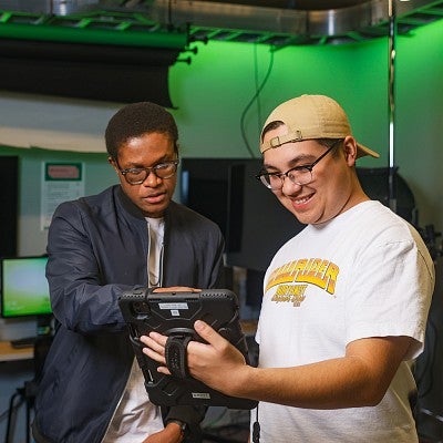Two SOJC students review an augmented reality experience designed with Snapchat in the SOJC immersive media lab