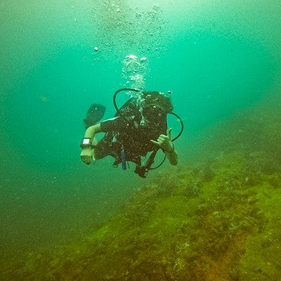 Eden McCall scuba dives in brilliant emerald water