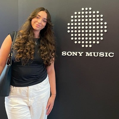 Elizabeth Briese poses next to a Sony Music sign at her advertising internship