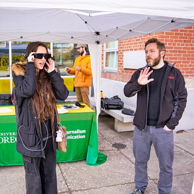 Luke Walker talks to a student wearing an AR headset