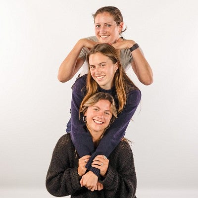 Three students pose in a column
