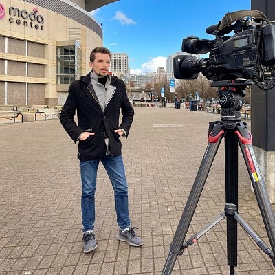 Galen Ettlin does a TV news broadcast in front of the Moda Center in Portland