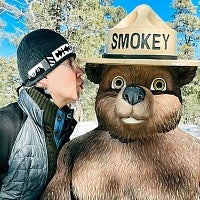 Betty Staniak kissing a statue of Smokey the Bear